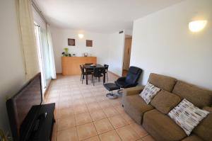 a living room with a couch and a table and chairs at Golive Bahia in Cambrils