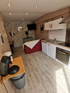 um quarto com uma cozinha e uma cama num quarto em La chaumière em Longues-sur-Mer