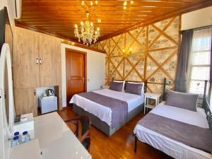een slaapkamer met 2 bedden en een kroonluchter bij Necip Bey Konağı in Antalya