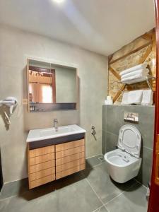 een badkamer met een wastafel, een toilet en een spiegel bij Necip Bey Konağı in Antalya
