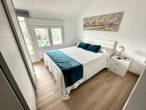 a bedroom with a bed with blue pillows at Apartamentos Sinás Playa in Raxó