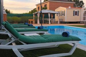 a row of chaise lounges next to a swimming pool at Hermosa Casa Vacacional La Promesa in Escalona