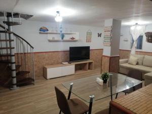 a living room with a couch and a television at Hermosa Casa Vacacional La Promesa in Escalona