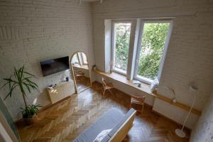 Habitación con 2 ventanas, mesa y sillas en Passage Apartment, en Ivano-Frankivsk