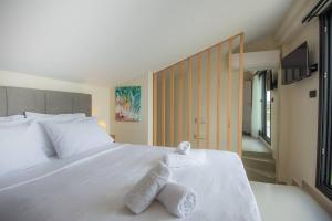 Un dormitorio con una cama blanca con toallas. en Agro Nostro-Agave with superb view, en Agios Nikolaos