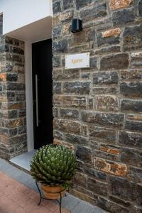 a plant sitting in front of a brick building at Agro Nostro-Agave with superb view in Agios Nikolaos