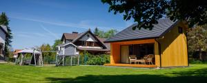 a small house with a table and chairs in a yard at Apartament i Domek Komfort in Rabka-Zdrój