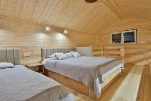 ラプカにあるApartament i Domek Komfortの木造キャビン内のベッドルーム1室(ベッド2台付)