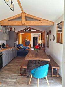 a kitchen with a wooden table and a blue chair at Maison piscine à 15m du Stadium in Toulouse