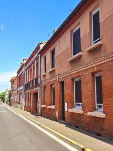 a red brick building on a city street at Maison piscine à 15m du Stadium in Toulouse