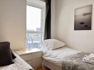 a white bedroom with a bed and a window at Modern Spacious 3 Bedroom Apartment At Richard Mortensens Vej With Balcony Close To The Royal Arena And Fields in Copenhagen