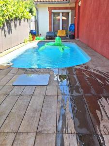 a small swimming pool in a yard with a house at Maison piscine à 15m du Stadium in Toulouse