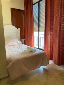 um quarto com uma cama e uma grande janela em Hotel Medina Centro em Jerez de la Frontera