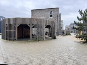 a building with a pavilion on a brick street at Modern Spacious 3 Bedroom Apartment At Richard Mortensens Vej With Balcony Close To The Royal Arena And Fields in Copenhagen