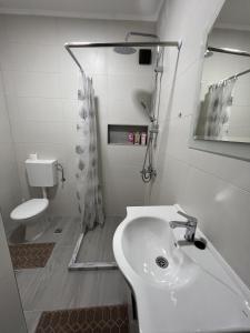 Baño blanco con lavabo y aseo en Apartment Relax, en Stolac