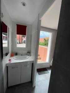 a bathroom with a sink and a large window at Chambre d'hôtes A l'ancre marine in Nice