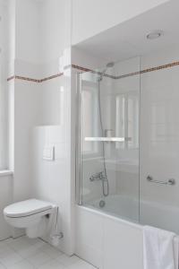 a white bathroom with a shower and a toilet at Hotel Ambiance in Prague