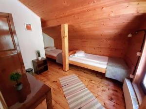 a room with two beds in a log cabin at Casa River in Băişoara