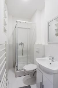uma casa de banho branca com chuveiro, WC e lavatório. em Mika Apartment and Studios em Zagreb