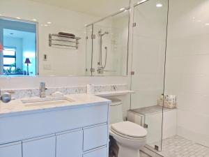 a white bathroom with a toilet and a shower at Waterfront Room2 with Private Bath near Marina in Gibsons