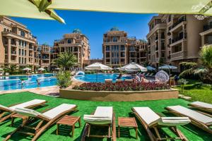 a resort with a pool and lawn chairs and buildings at Апартамент под наем С208 в Афродита Гарденс in Sunny Beach
