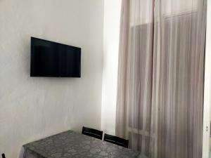 una camera con tavolo e televisore a parete di BILOCALE Villa Lara a Cesenatico