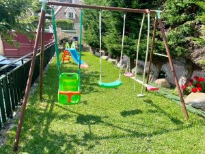 a playground with swings in a yard at Apartamentos Sinás Playa in Raxó