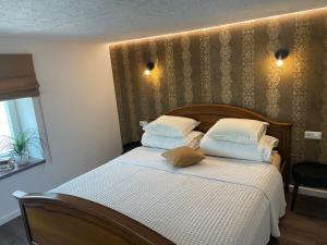 Schlafzimmer mit einem Bett mit weißer Bettwäsche und Kissen in der Unterkunft Kęstučio 55 in Kaunas