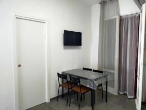 uma mesa de jantar com duas cadeiras e uma televisão na parede em BILOCALE Villa Lara em Cesenatico