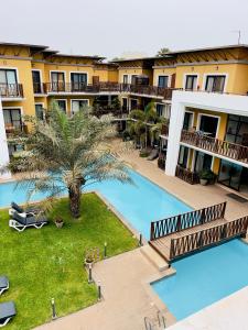 an aerial view of a hotel with a pool and a palm tree at Forest view flat in Sere Kunda