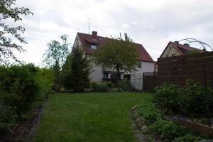 una casa con un patio con una valla y un patio en Pension Wob en Wolfsburg