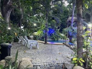 un patio con sillas y una piscina por la noche en EcoHostal Rio Piedra en El Zaino