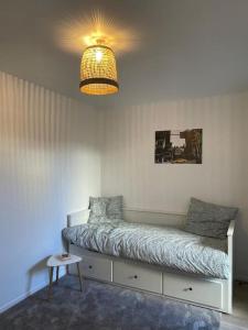 a bedroom with a bed with a lamp and a table at Studio 28 m2 & jardin privatif 20 m2 in Montigny-le-Bretonneux