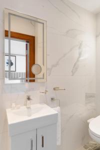 a white bathroom with a sink and a mirror at Sonder The Voyage in London