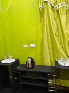 a room with a green wall and two tables with cups at Mario Algarin in Puerto Iguazú