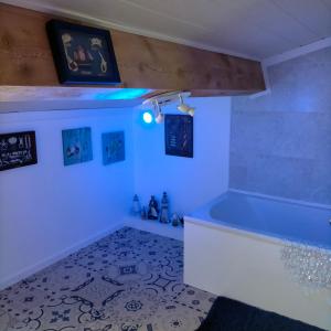 a bathroom with a tub and pictures on the wall at Alaric Lodge: gîte champêtre avec parking privé. in Comigne
