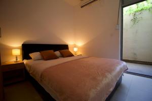 een slaapkamer met een bed met 2 lampen en een raam bij Waterfront Apartments in Kotor