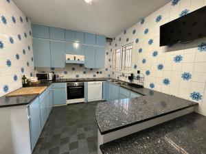 una cocina con armarios azules y electrodomésticos blancos en Casa L'Avi, en Plegamans