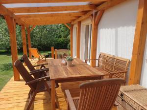 a wooden table and chairs on a wooden deck at Chalupa Pasečná in Přední Výtoň