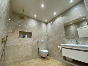 ein Badezimmer mit einem weißen WC und einem Waschbecken in der Unterkunft Magnifique Villa in Beni Mellal