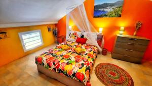 um quarto com paredes cor-de-laranja, uma cama e uma cómoda em Studio T1 bis La Belle Vue, vue mer, wifi, plage à 50m em Le Moule