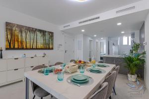 una cucina e una sala da pranzo con tavolo e sedie di Puerto Marina Luxury 2BDR Apartment with Sea View a Benalmádena