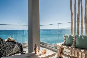 una camera con una grande finestra con vista sull'oceano di Khroma Luxury Suite 1 Beach front apartment a Hersonissos