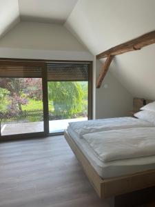 a bedroom with a bed and a large window at Turistična Kmetija Pungračič in Zavrč
