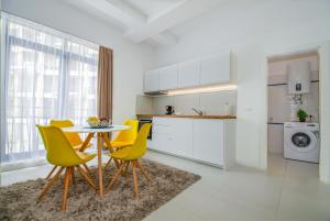 a kitchen with a table and yellow chairs in a room at Forest by the sea in Jupiter +12 photos