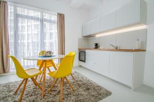 a kitchen with a table and two yellow chairs at Forest by the sea in Jupiter