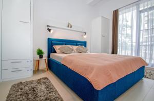 a bedroom with a blue bed and a window at Forest by the sea in Jupiter
