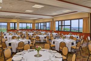 a banquet hall with white tables and chairs and windows at Sheraton Denver West Hotel in Lakewood