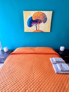 a bedroom with a bed with a painting of a tree at Waterfront Gallipoli 150 mt dal mare in Gallipoli
