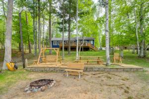 una cabaña en el bosque con bancos y chimenea en Lakefront Cabin with Deck, Games, and Views!, 